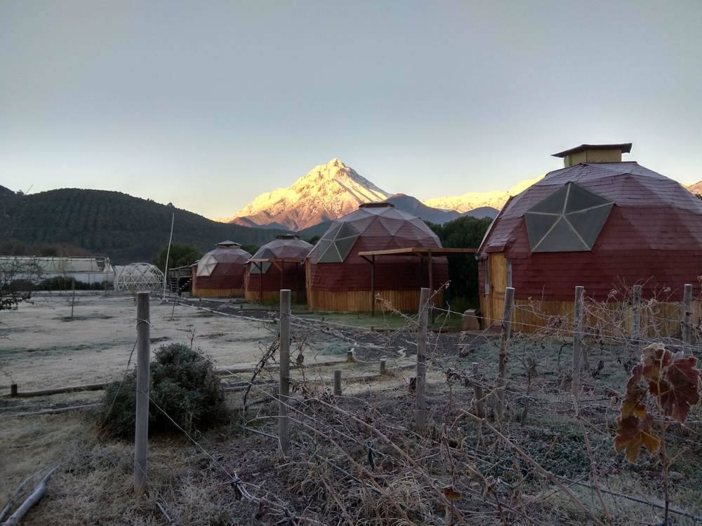 Domos al amanecer con la cordillera nevada