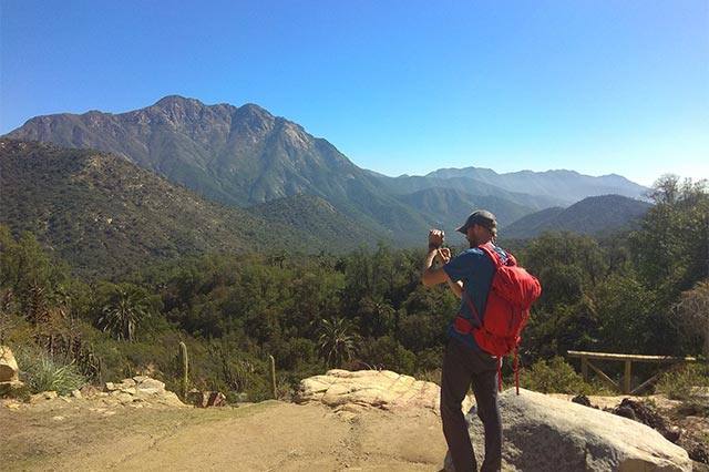 Excursionista fotografiando el Parque Nacional La Campana
